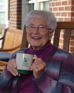 senior woman holding mug smiling