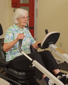 senior woman using rehab therapy bike