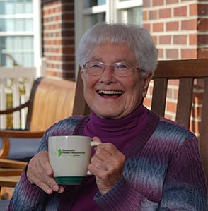 Woman holding coffee mug at Independent Living Facility, Maple Crest